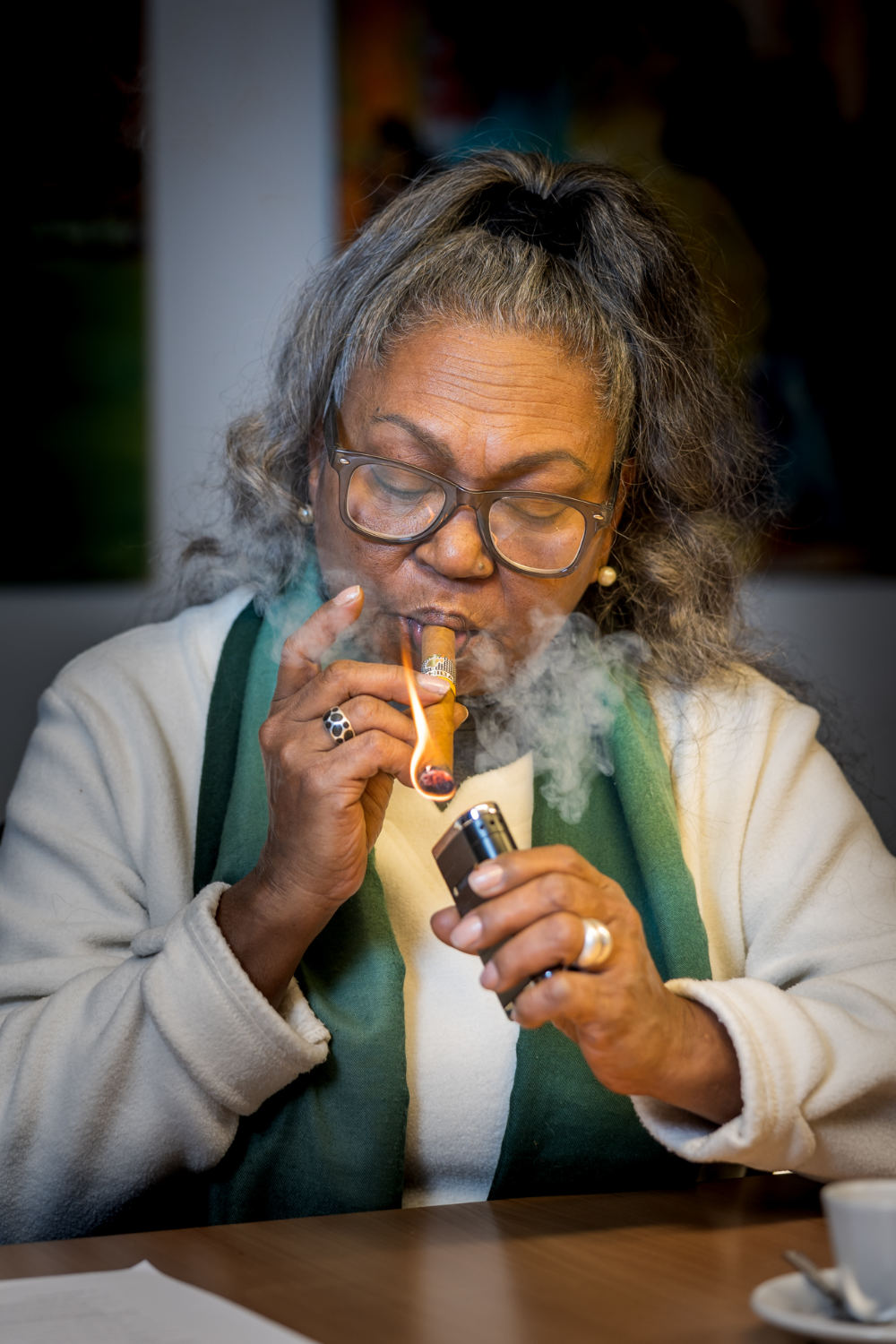 Juana "Juanita" Ramos Guerra enciende su Cohiba, un momento lleno de orgullo y devoción. Lleva más de cinco décadas dando forma a la historia de Cohiba El Laguito con corazón y habilidad. 